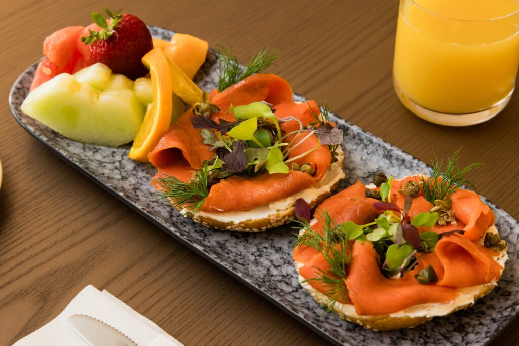 Smoked salmon toasts and fruit on a stone platter