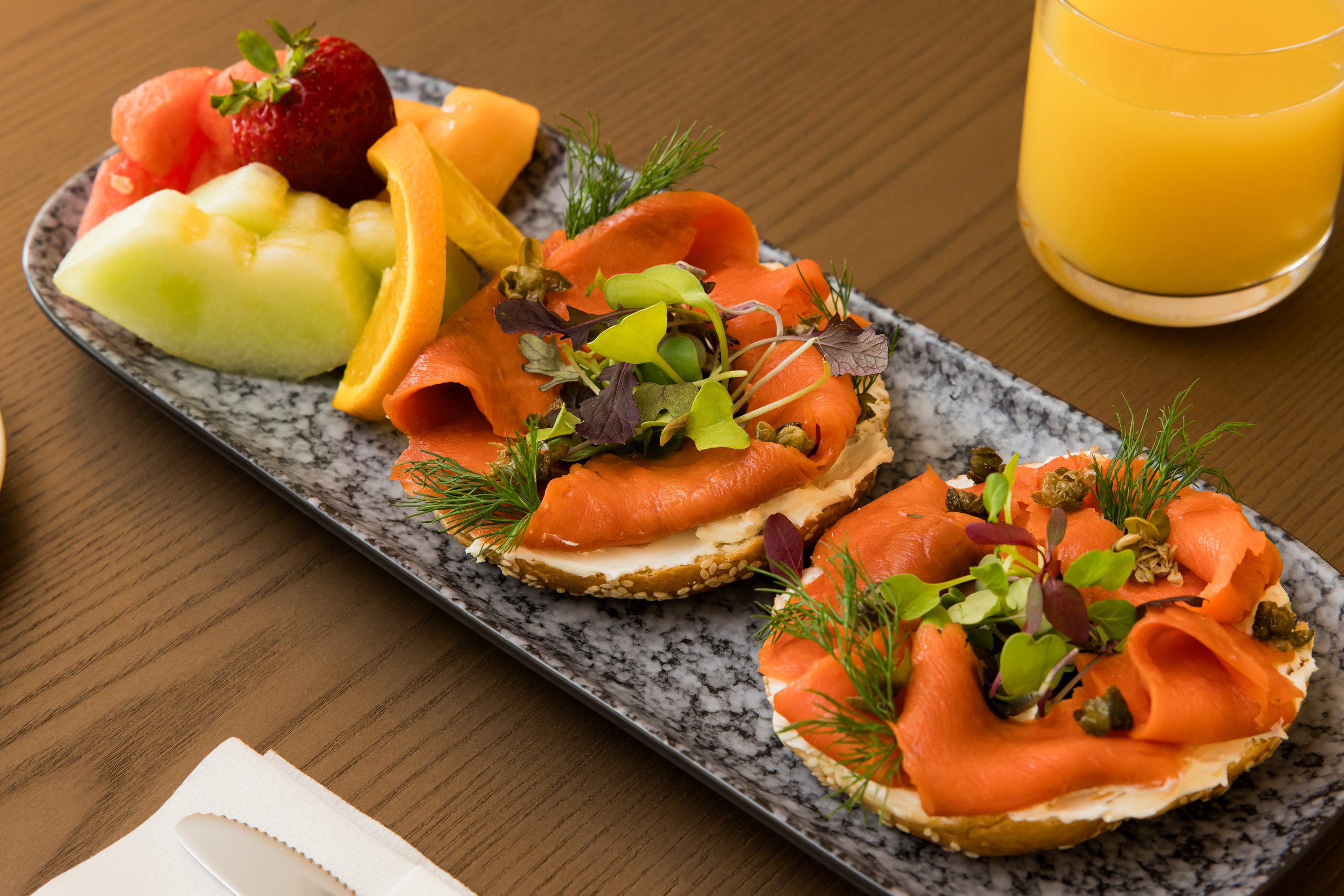 Smoked salmon toasts and fruit on a stone platter