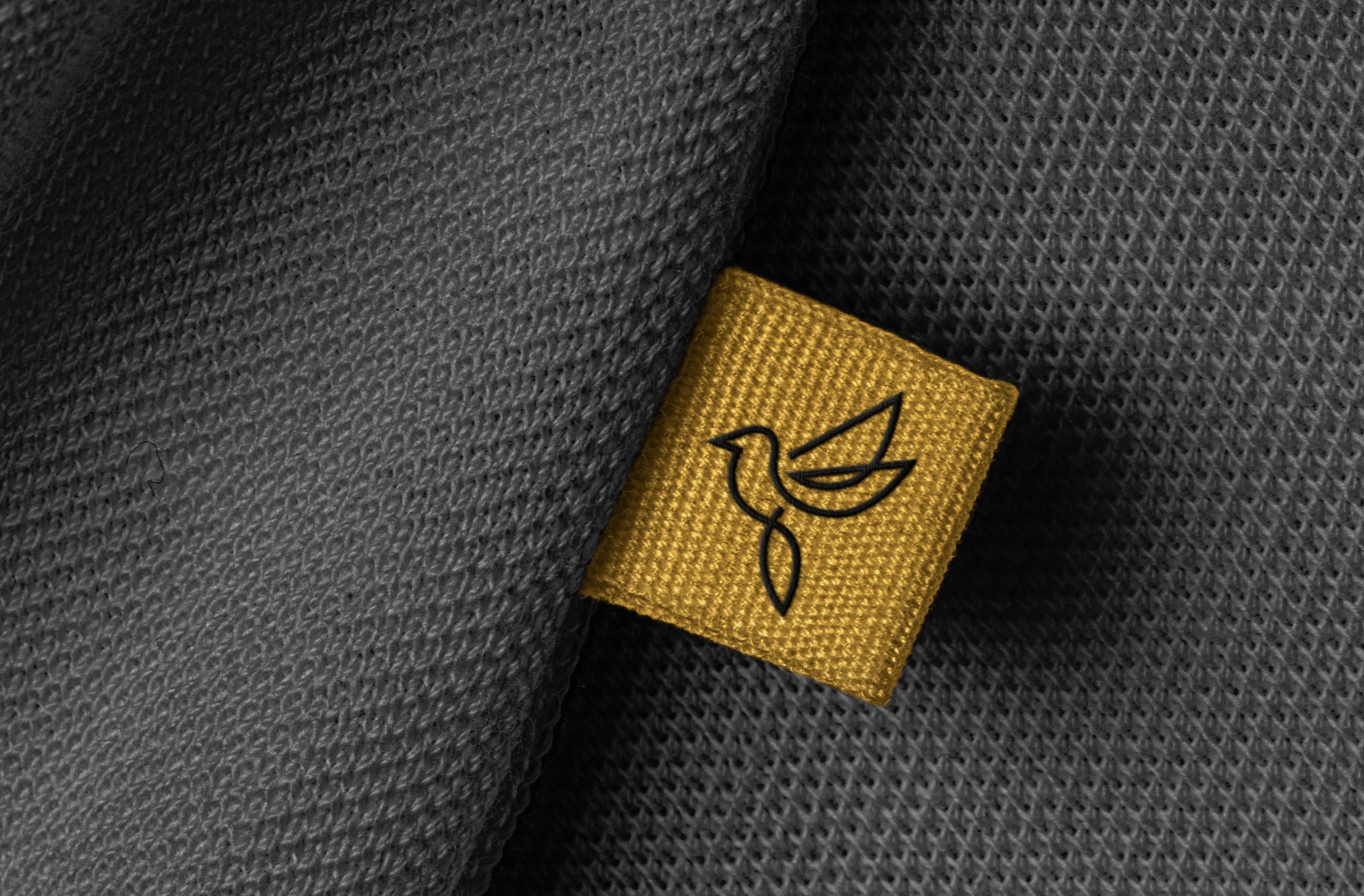Woven Hotel bird logo on a mustard fabric label